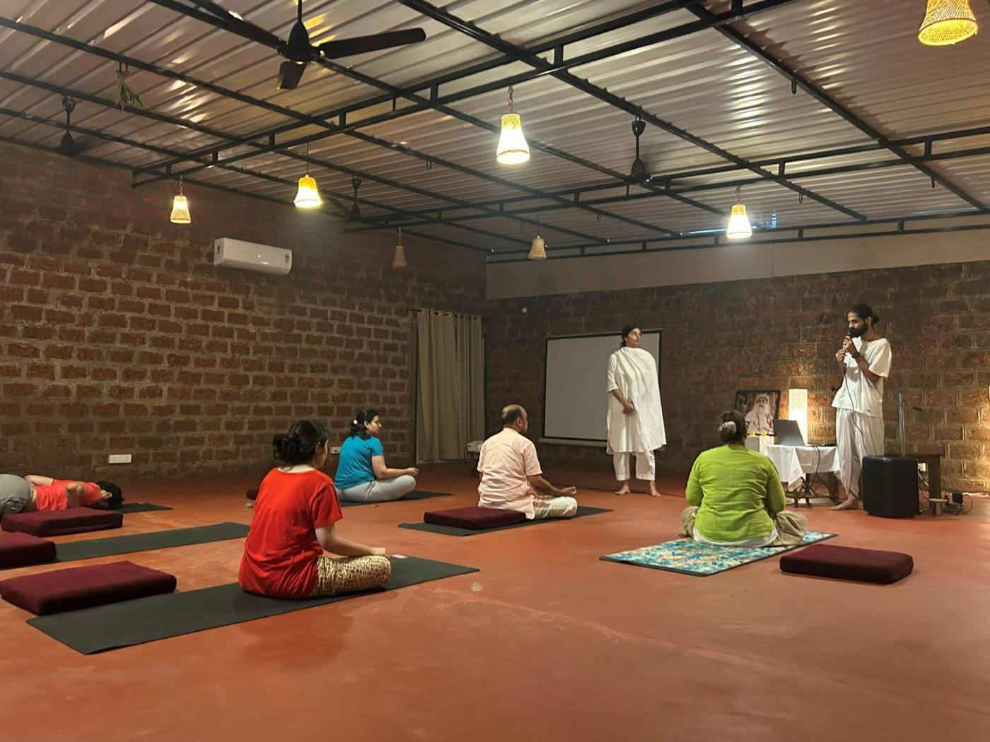 A group practice session in the meditation hall, Goa retreat.