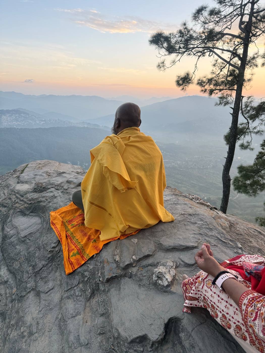 A seeker sitting alone on the ridge at Kasar Devi, looking out over the hills at sunset.