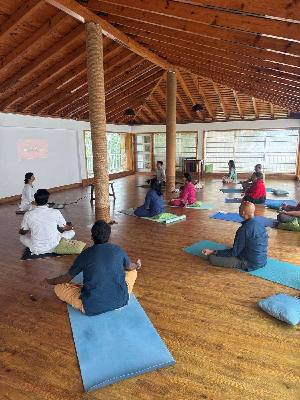 A morning group practice in a wooden hall at Kasar Devi.