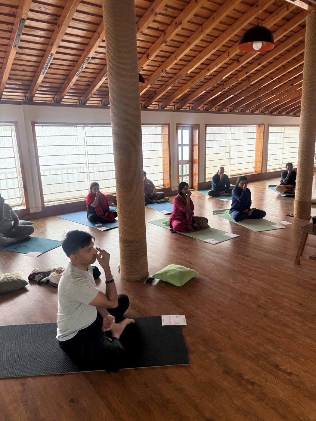 The group seated in meditation in a wooden hall at Kasar Devi.