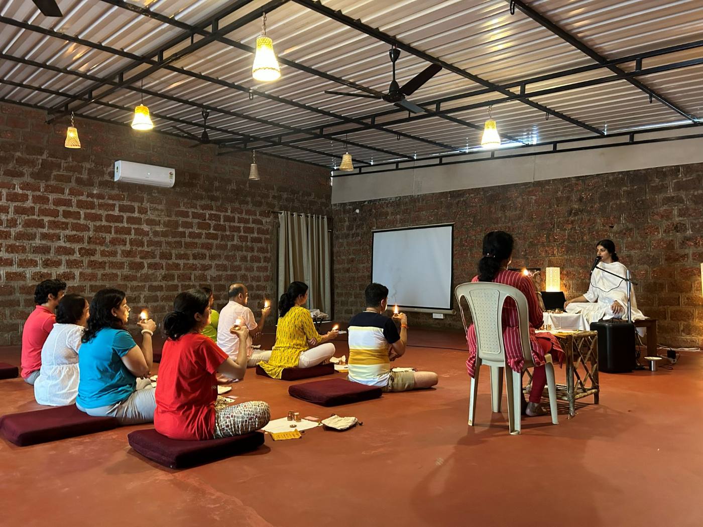 The group seated together for a meditation session in the hall, Goa retreat.